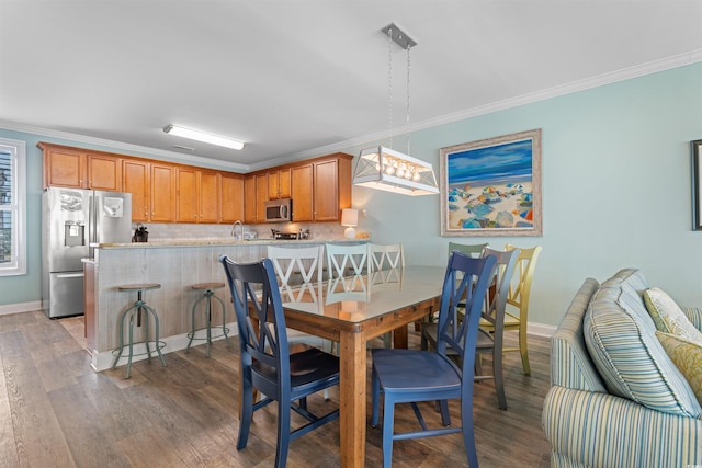 703 S Waccamaw Dr, Garden City Beach, SC 29576 - dining room featuring wood finished floors, crown molding, and baseboards
