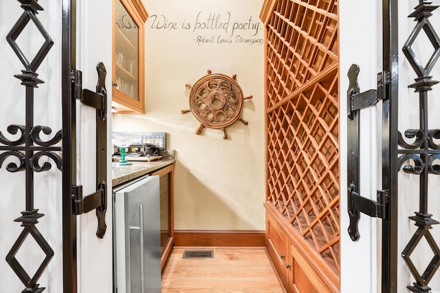 509 Heston Point Dr, Pawleys Island, SC 29585 - wine cellar with bar with sink, baseboards, and light wood-style floors