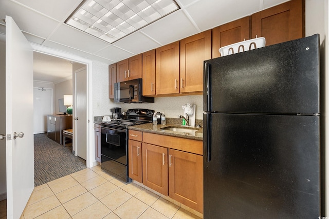 1105 S Ocean Blvd Unit 928, Myrtle Beach, SC 29577 - kitchen featuring black appliances, a sink, light tile patterned floors, brown cabinets, and dark stone counters
