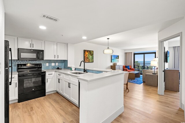 7100 N Ocean Blvd N Unit 321, Myrtle Beach, SC 29572 - kitchen featuring black appliances, a sink, open floor plan, light wood-type flooring, and recessed lighting