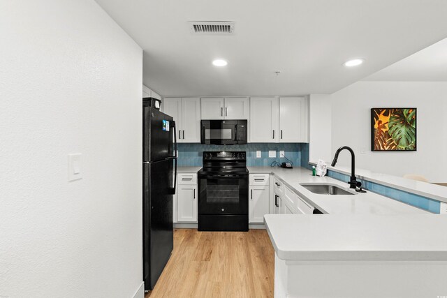 7100 N Ocean Blvd N Unit 321, Myrtle Beach, SC 29572 - kitchen with black appliances, a sink, a peninsula, light countertops, and white cabinetry