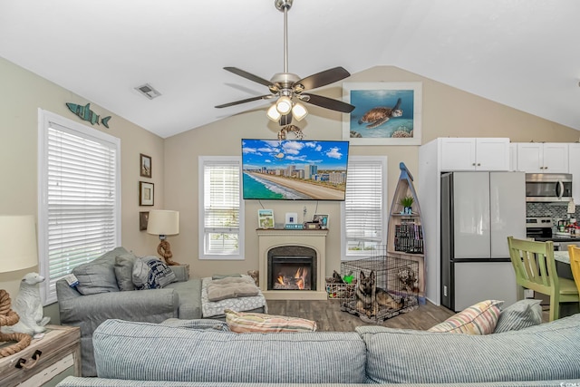3827 El Duce Pl, Myrtle Beach, SC 29588 - living room with vaulted ceiling, wood finished floors, ceiling fan, and a warm lit fireplace