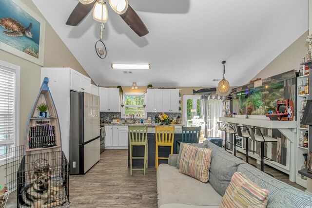 3827 El Duce Pl, Myrtle Beach, SC 29588 - kitchen with freestanding refrigerator, lofted ceiling, ceiling fan, tasteful backsplash, and light wood-style floors