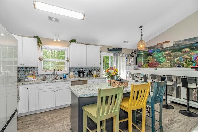 3827 El Duce Pl, Myrtle Beach, SC 29588 - kitchen with a sink, light wood-style flooring, lofted ceiling, backsplash, and healthy amount of natural light