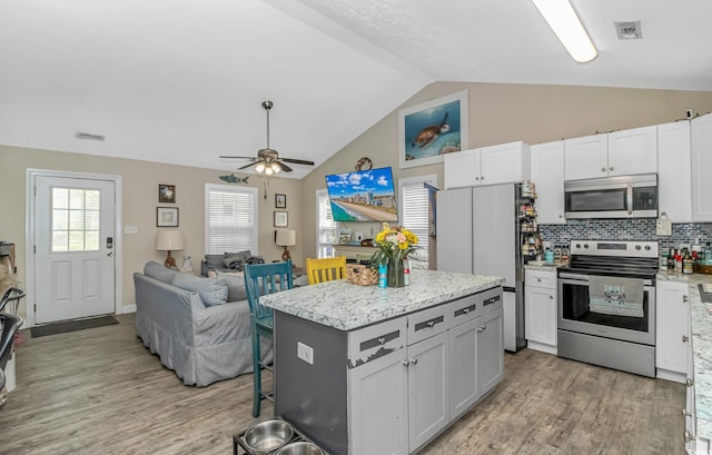 3827 El Duce Pl, Myrtle Beach, SC 29588 - kitchen with stainless steel appliances, light wood-style flooring, a kitchen island, open floor plan, and ceiling fan