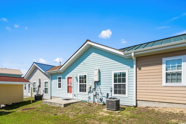 4338 Grande Harbour Blvd, Little River, SC 29566 - back of house with central AC unit, a standing seam roof, metal roof, and a lawn