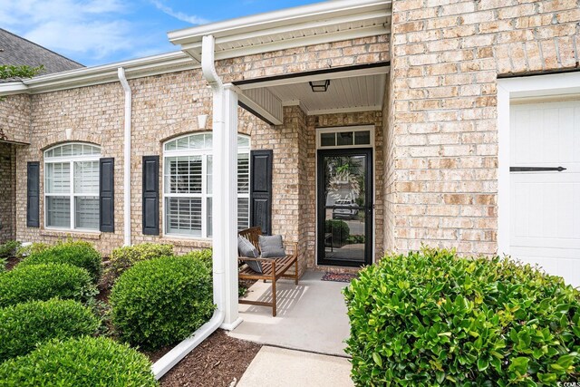 3210 Volterra Way Unit 3210, Myrtle Beach, SC 29579 - view of exterior entry with brick siding and a garage