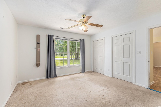 3429 Mishoe St, Loris, SC 29569 - unfurnished bedroom with two closets, carpet, a ceiling fan, and a textured ceiling