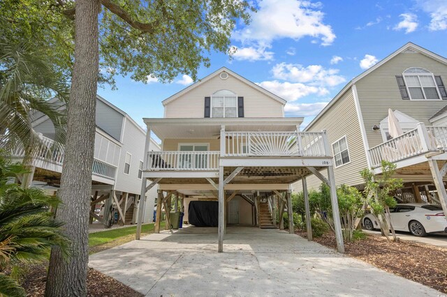 beach home featuring stairway, driveway, a porch, and a carport