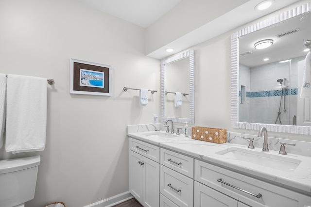 full bath with a stall shower, toilet, and double vanity