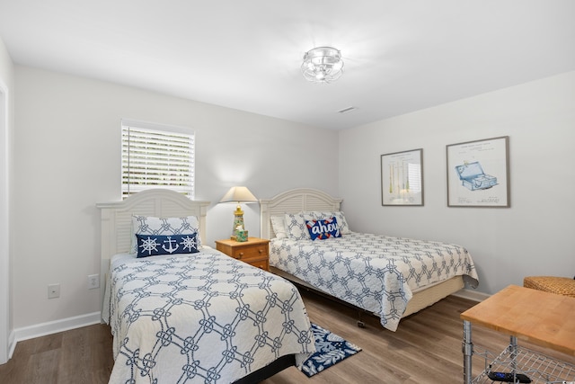 bedroom featuring wood finished floors and baseboards