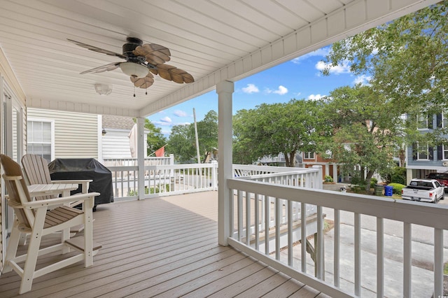 wooden terrace with a ceiling fan and a grill