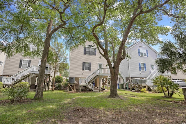 back of property featuring stairs, a yard, and central AC