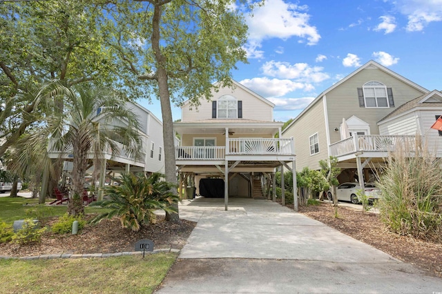 beach home with a carport, concrete driveway, and a porch