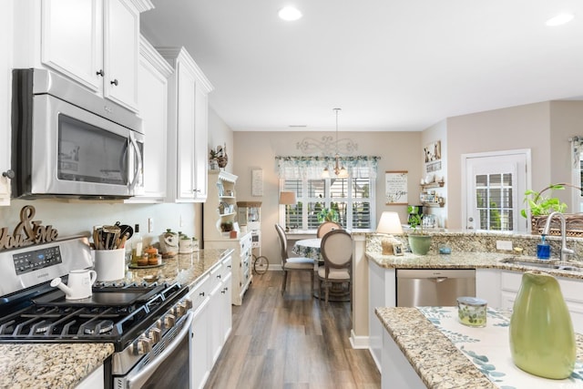 kitchen with appliances with stainless steel finishes, a sink, light wood-style floors, plenty of natural light, and recessed lighting