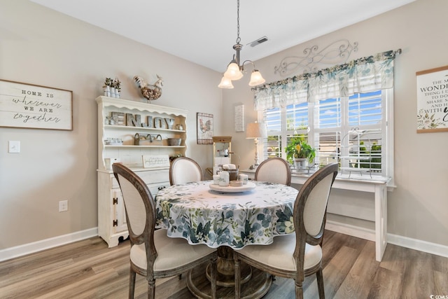 dining space with light wood-type flooring and baseboards