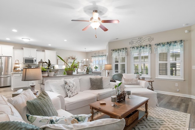living room featuring a ceiling fan, healthy amount of natural light, light wood-style flooring, recessed lighting, and baseboards