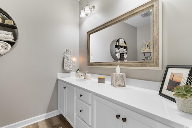 bathroom featuring vanity, wood finished floors, and baseboards