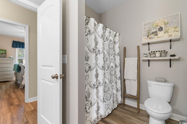 full bathroom featuring wood finished floors, toilet, baseboards, and curtained shower