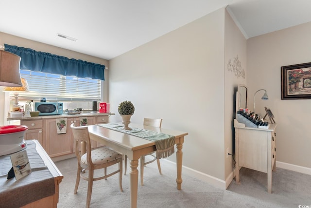 dining area featuring baseboards and light carpet