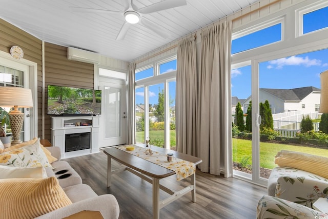 sunroom / solarium with a wall mounted air conditioner and wood finished floors