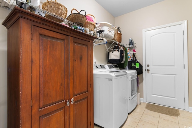 laundry room with washer and dryer, light tile patterned floors, and cabinet space