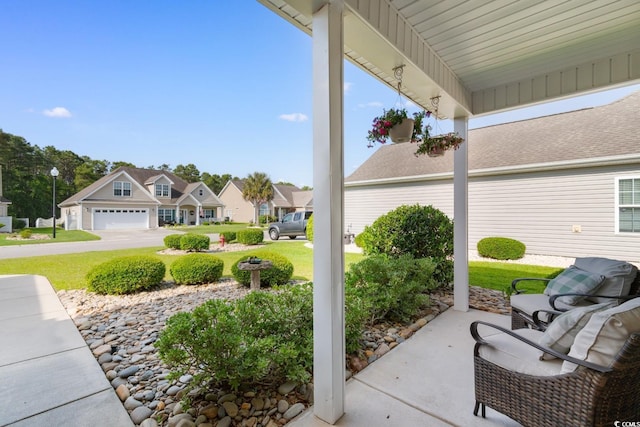 view of patio / terrace with a garage and a residential view