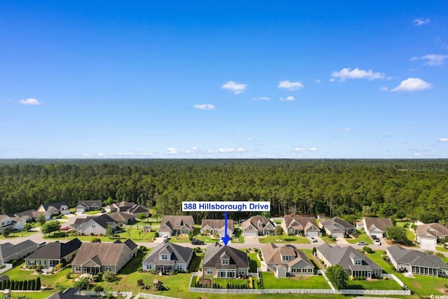 aerial view of residential area featuring a forest