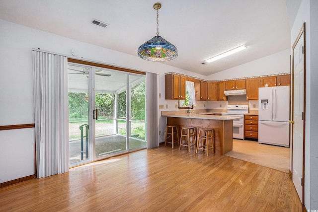 4311 Bradford Cir, Myrtle Beach, SC 29588 - kitchen with white appliances, under cabinet range hood, light wood-style flooring, a peninsula, and brown cabinetry