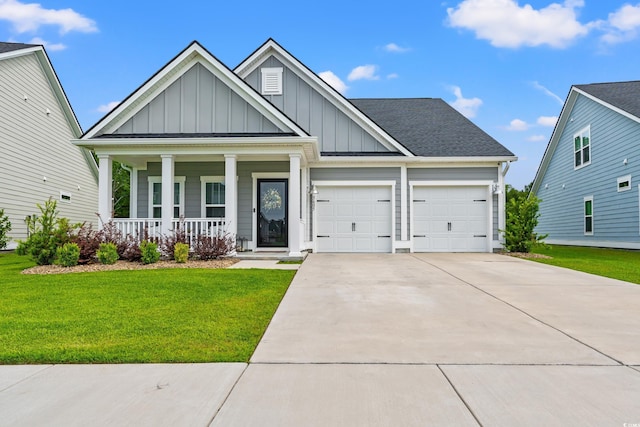 view of front of home with board and batten siding, covered porch, an attached garage, a front yard, and concrete driveway