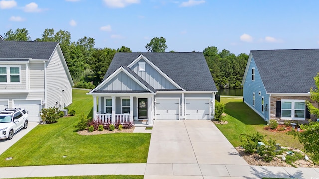 view of front of home with board and batten siding, concrete driveway, covered porch, a front lawn, and roof with shingles