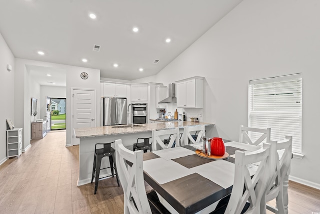 dining room with light wood-style floors, recessed lighting, baseboards, and vaulted ceiling