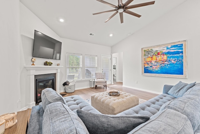 living area featuring ceiling fan, wood finished floors, recessed lighting, a glass covered fireplace, and high vaulted ceiling