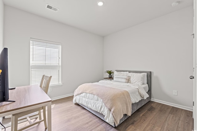 bedroom with wood finished floors, baseboards, and recessed lighting