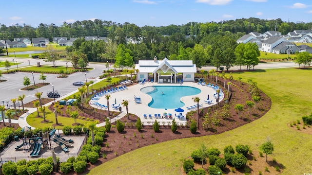 community pool with a residential view, a patio, and view of scattered trees