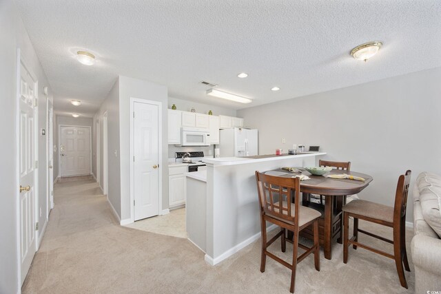 4506 W Harbor Ct Unit U-15, Little River, SC 29566 - kitchen featuring white appliances, light carpet, white cabinetry, a textured ceiling, and recessed lighting