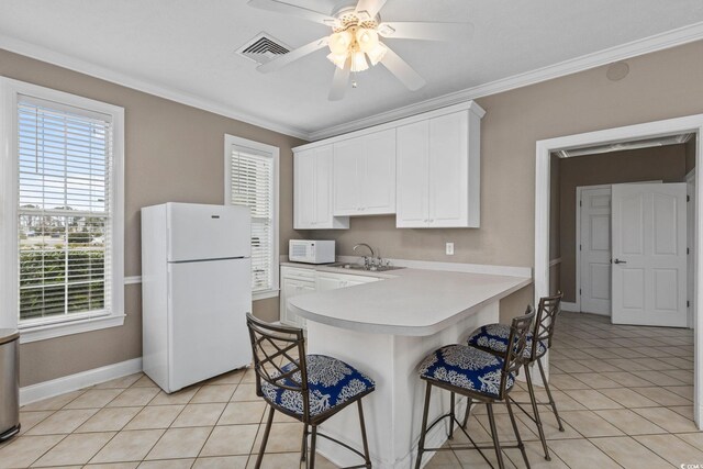 4506 W Harbor Ct Unit U-15, Little River, SC 29566 - kitchen with white appliances, ceiling fan, light tile patterned floors, ornamental molding, and a kitchen breakfast bar