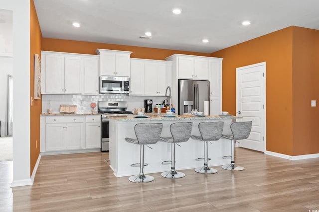 3021 Sistine St, Myrtle Beach, SC 29579 - kitchen featuring stainless steel appliances, an island with sink, a kitchen breakfast bar, white cabinetry, and recessed lighting