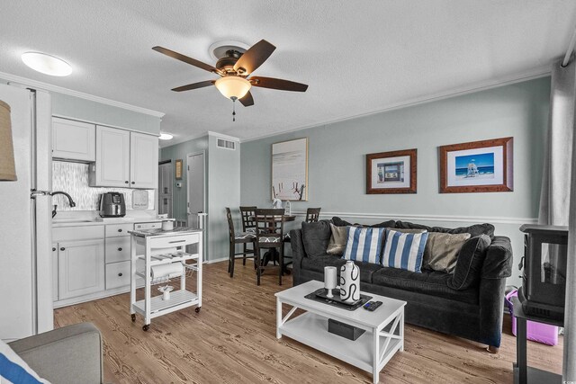 6000 N Ocean Blvd Unit 119, North Myrtle Beach, SC 29582 - living area with ornamental molding, a ceiling fan, light wood-type flooring, and a textured ceiling