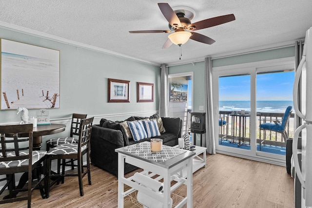 6000 N Ocean Blvd Unit 119, North Myrtle Beach, SC 29582 - living room featuring light wood finished floors, a ceiling fan, a textured ceiling, crown molding, and a water view