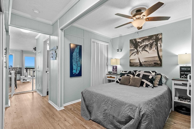 6000 N Ocean Blvd Unit 119, North Myrtle Beach, SC 29582 - bedroom featuring crown molding, a textured ceiling, light wood finished floors, baseboards, and ceiling fan