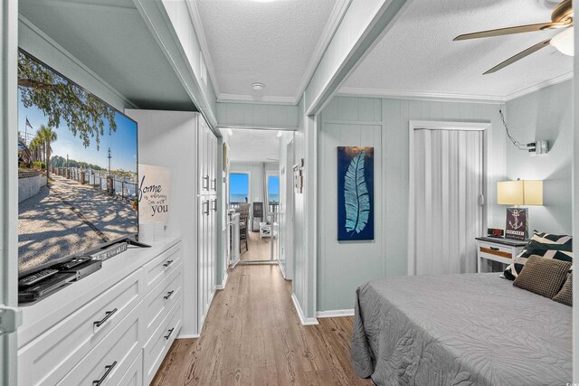 6000 N Ocean Blvd Unit 119, North Myrtle Beach, SC 29582 - bedroom with crown molding, light wood-style floors, a textured ceiling, and ceiling fan