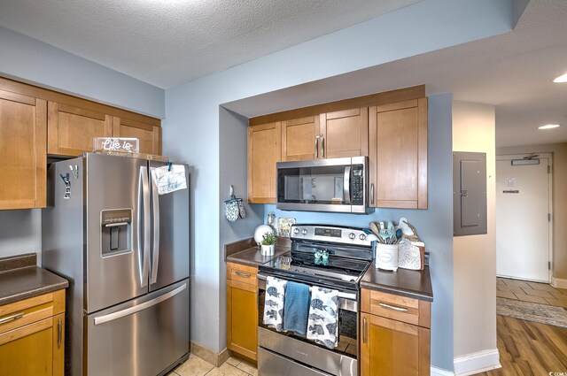 2100 Sea Mountain Hwy Unit 202, North Myrtle Beach, SC 29582 - kitchen featuring stainless steel appliances, dark countertops, electric panel, recessed lighting, and a textured ceiling