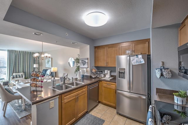 2100 Sea Mountain Hwy Unit 202, North Myrtle Beach, SC 29582 - kitchen with stainless steel appliances, a sink, dark countertops, a peninsula, and open floor plan