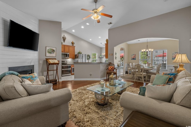 living room featuring arched walkways, ceiling fan, wood finished floors, recessed lighting, and a large fireplace