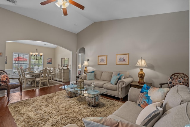 living room featuring arched walkways, ceiling fan, a chandelier, dark wood-type flooring, and high vaulted ceiling