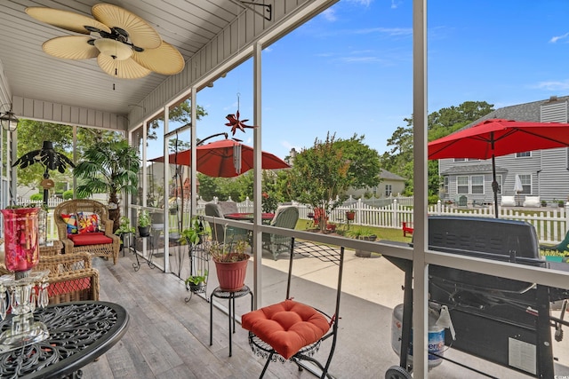 sunroom / solarium featuring a ceiling fan