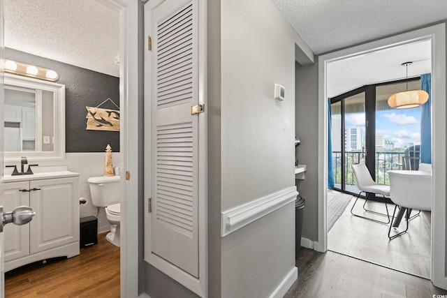 208 74th Ave N Unit 2-417, Myrtle Beach, SC 29572 - bathroom featuring a closet, wood finished floors, vanity, a textured ceiling, and tile walls
