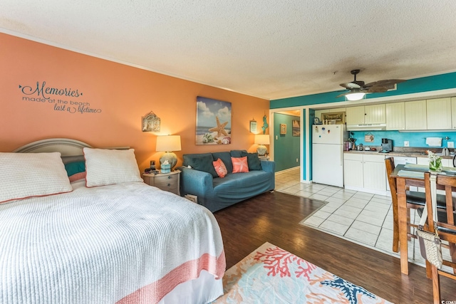 415 Ocean Creek Dr Unit 2330, Myrtle Beach, SC 29572 - bedroom with freestanding refrigerator, a textured ceiling, light wood finished floors, ornamental molding, and a ceiling fan