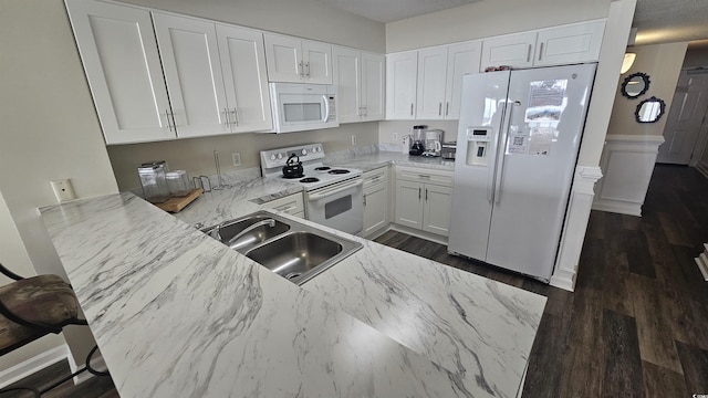 102 N Ocean Blvd Unit 405, North Myrtle Beach, SC 29582 - kitchen with white appliances, a sink, white cabinets, light stone counters, and wainscoting